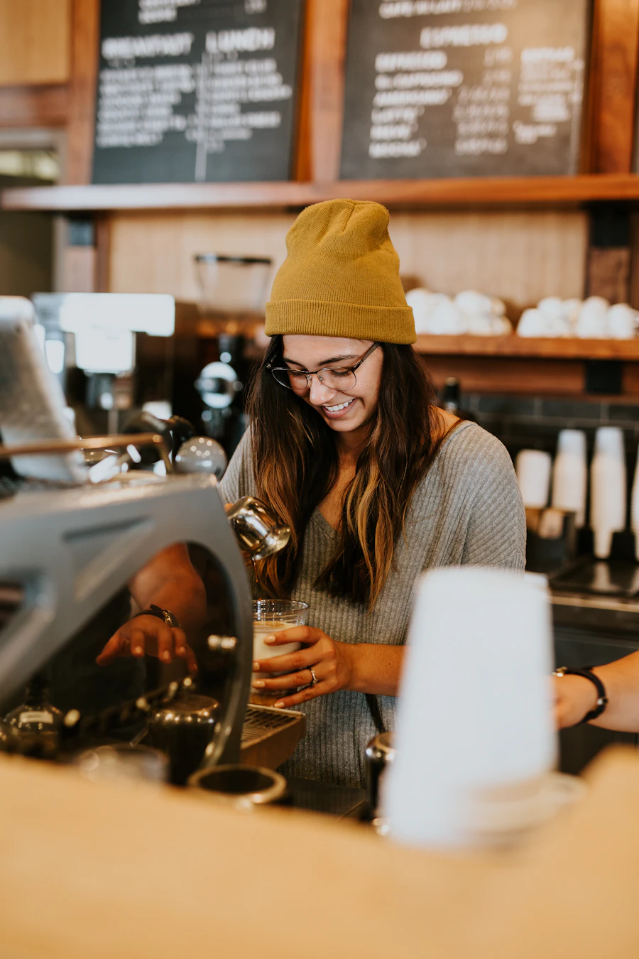 A barista preparing coffee behind a café counter